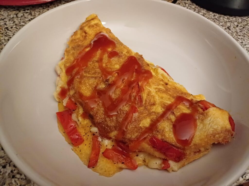 Cheese and red pepper omelette with hot sauce
