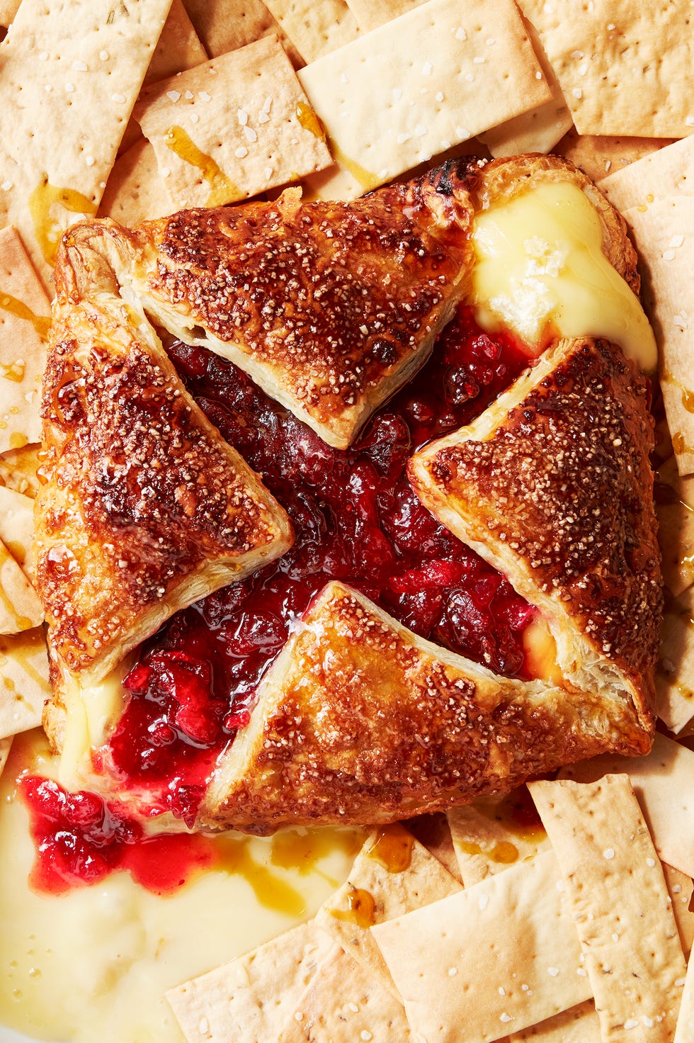 wrapped baked brie topped with cranberry and maple and served with crackers
