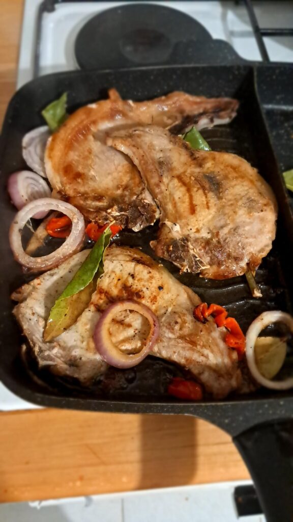 Pork chops on the grill with bay leaves, red onions and habanero peppers