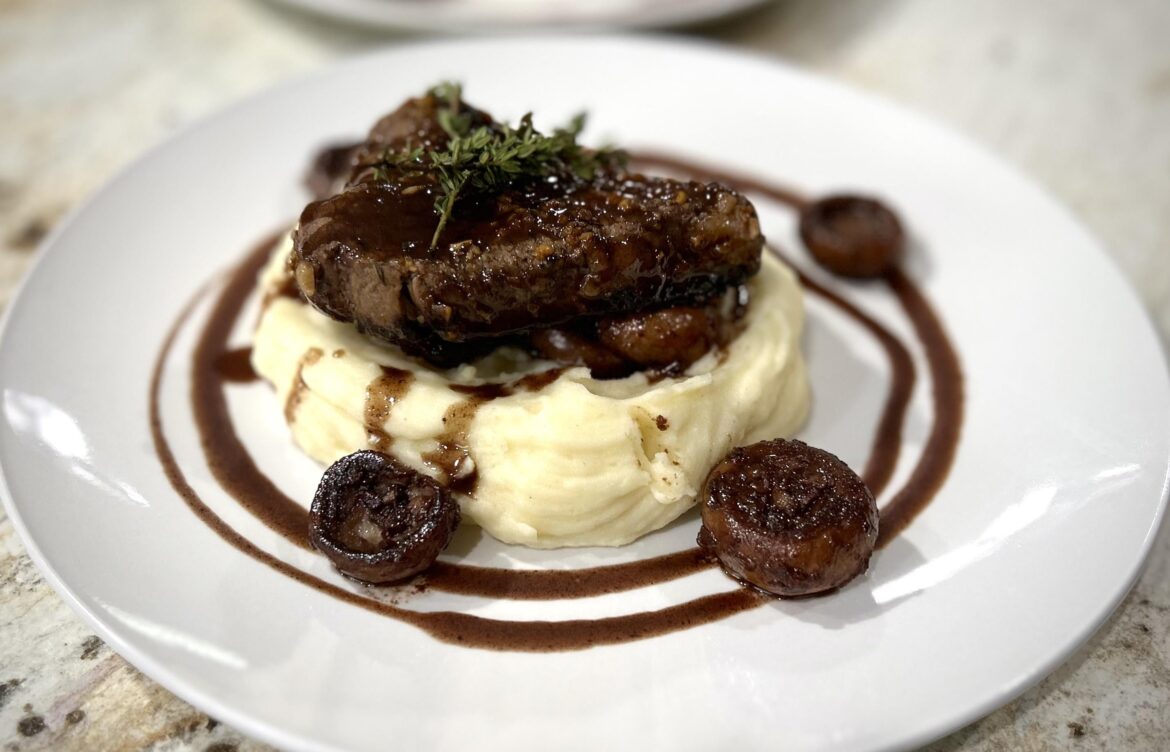 Sirloin with sautéed white mushrooms, whipped Yukon yellow potatoes, drizzled with a red wine reduction and garnished with thyme