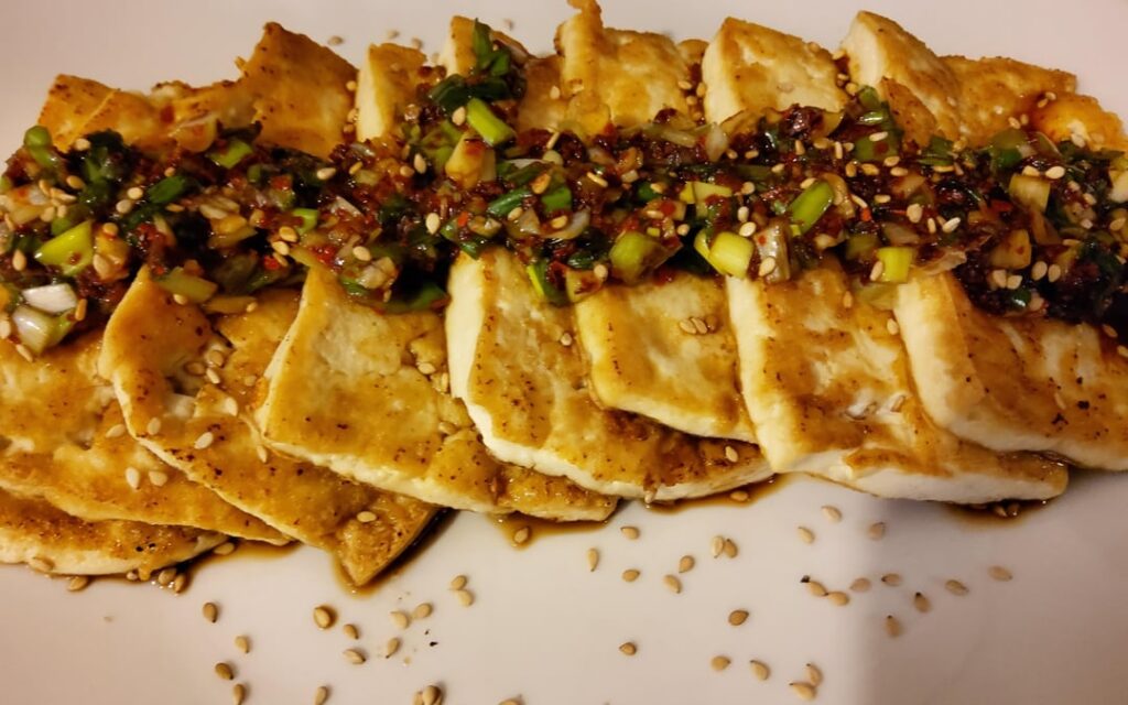 Pan fried tofu topped with spicy sauce