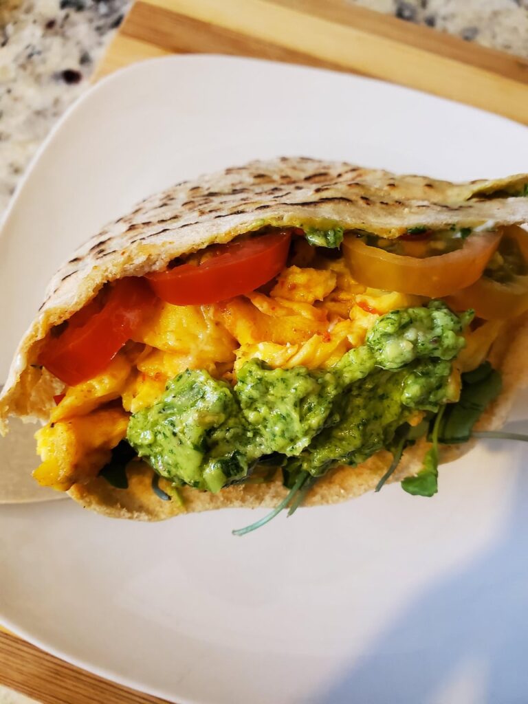 Made a healthy pocket breakfast sandwich for a change. Soft scrambled eggs topped with hot chili pepper paste, sliced avocado and grape tomatoes, microgreens and homemade avocado cilantro sauce.
