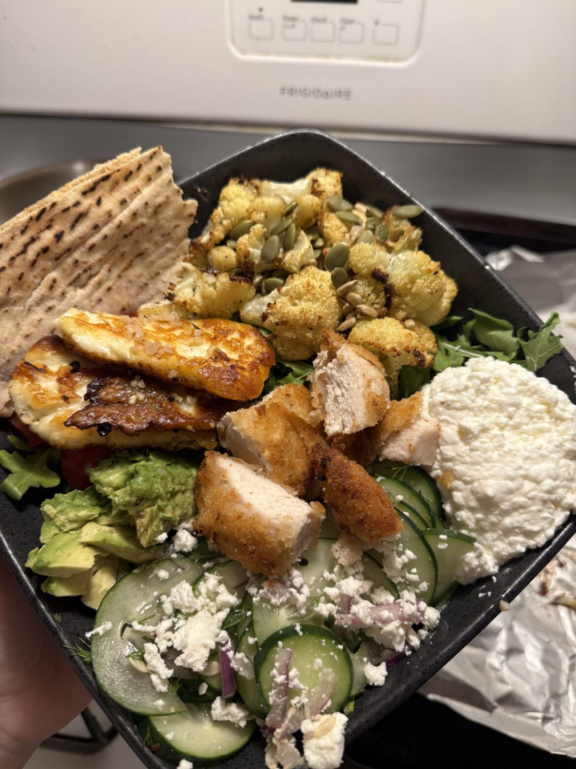 50 grams of protein, 650 calories: arugula, roasted cauliflower, cottage cheese, halloumi, cucumber, avocado and more!