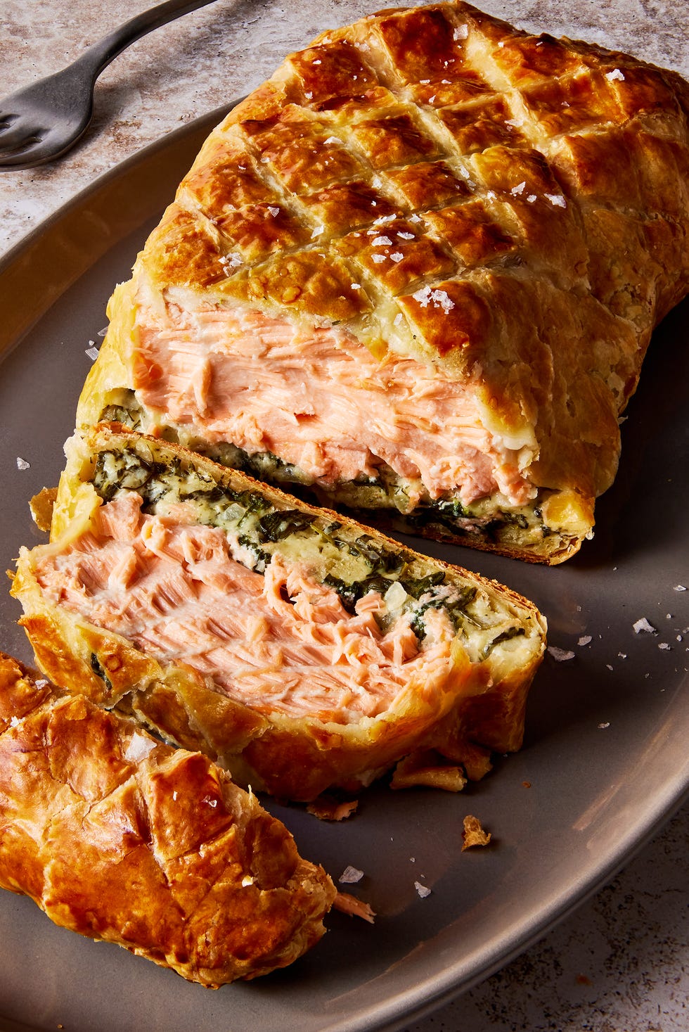 layers of salmon and cream spinach inside of puff pastry