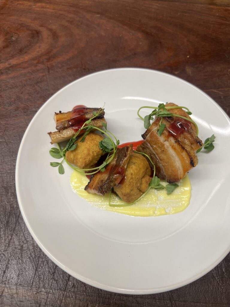Pork belly, poblano corn fritters, hibiscus chipotle gel, honey-garlic aioli, pea shoots.