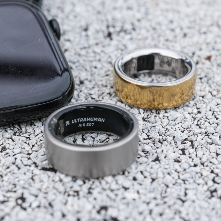 A close up of the Ultrahuman Ring Air in front of the Oura Ring 4 and Apple Watch Series 10.