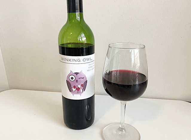 a bottle of cabernet next to a glass of red wine