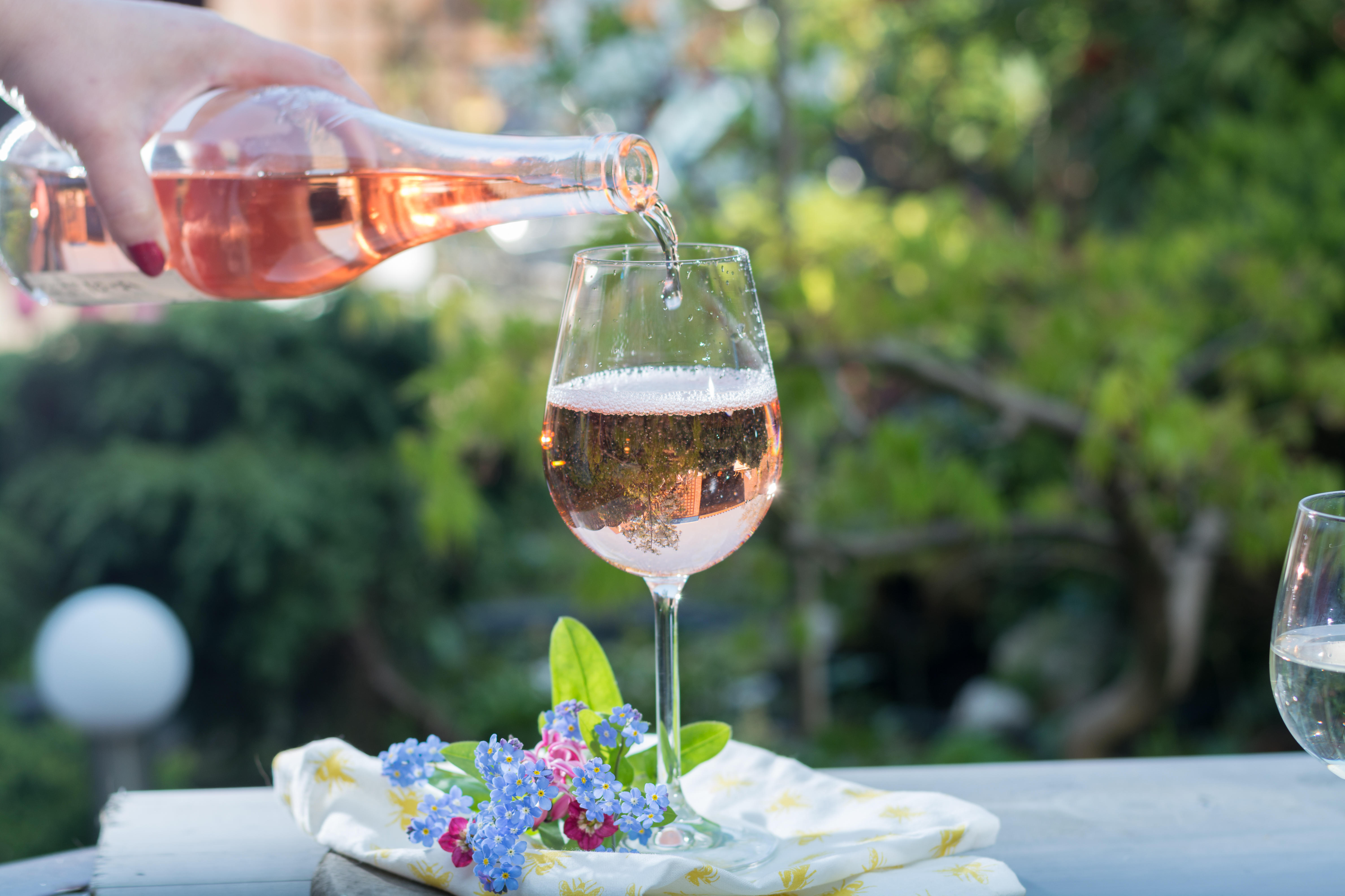 A glass of rosé wine being poured