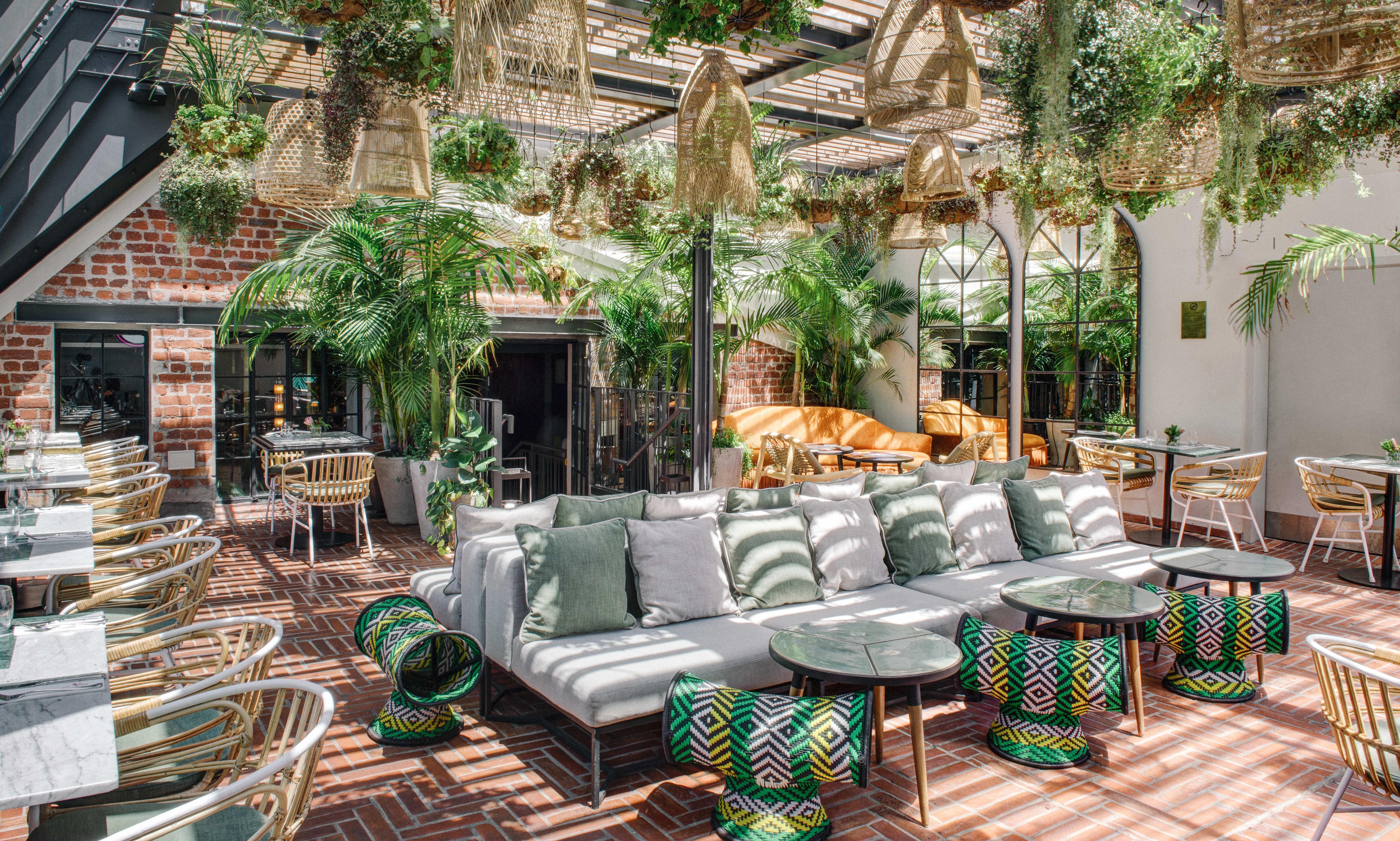 Gorgeous George Hotel patio with seating and hanging plants.