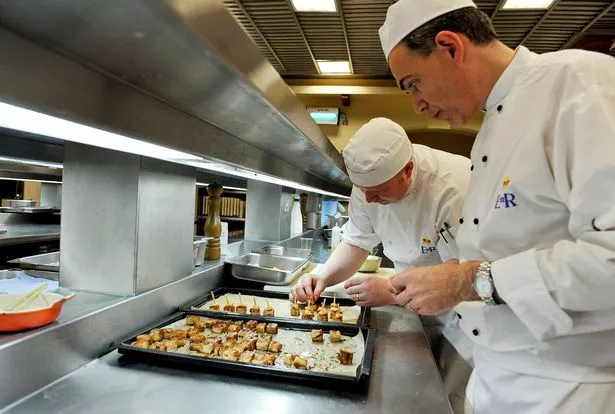 ATTENTION EDITORS - EMBARGO, RELEASABLE TUESDAY 29 MARCH AT 0001 GMT - THIS RESTRICTION APPLIES TO ALL MEDIA, INCLUDING WEBSITES  Royal Chef Mark Flanagan (R) Head of Kitchens at Buckingham Palace, London, watches as food is prepared, in the kitchens at Buckingham Palace, London on March 25, 2011, as preparetions for the forthcoming wedding of Prince William and Kate Middleton are underway. The second-in-line to the throne marries his university sweetheart on April 29 at Westminster Abbey, in an event that has become a global media sensation ever since they announced their engagement last November.  AFP PHOTO/WPA POOL/Nick Ansell (Photo credit should read Nick Ansell/AFP via Getty Images)