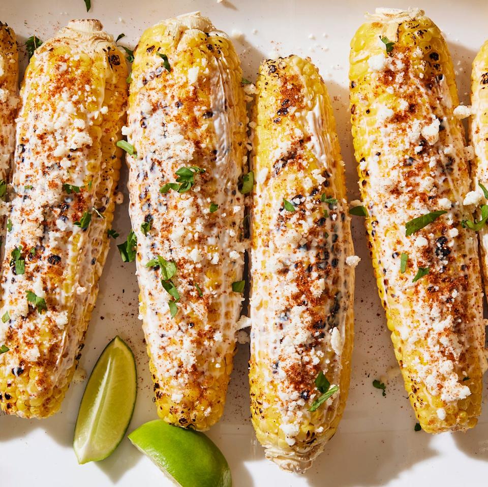 grilled corn topped with a creamy mixture, cotija cheese, chili powder, cilantro and lime