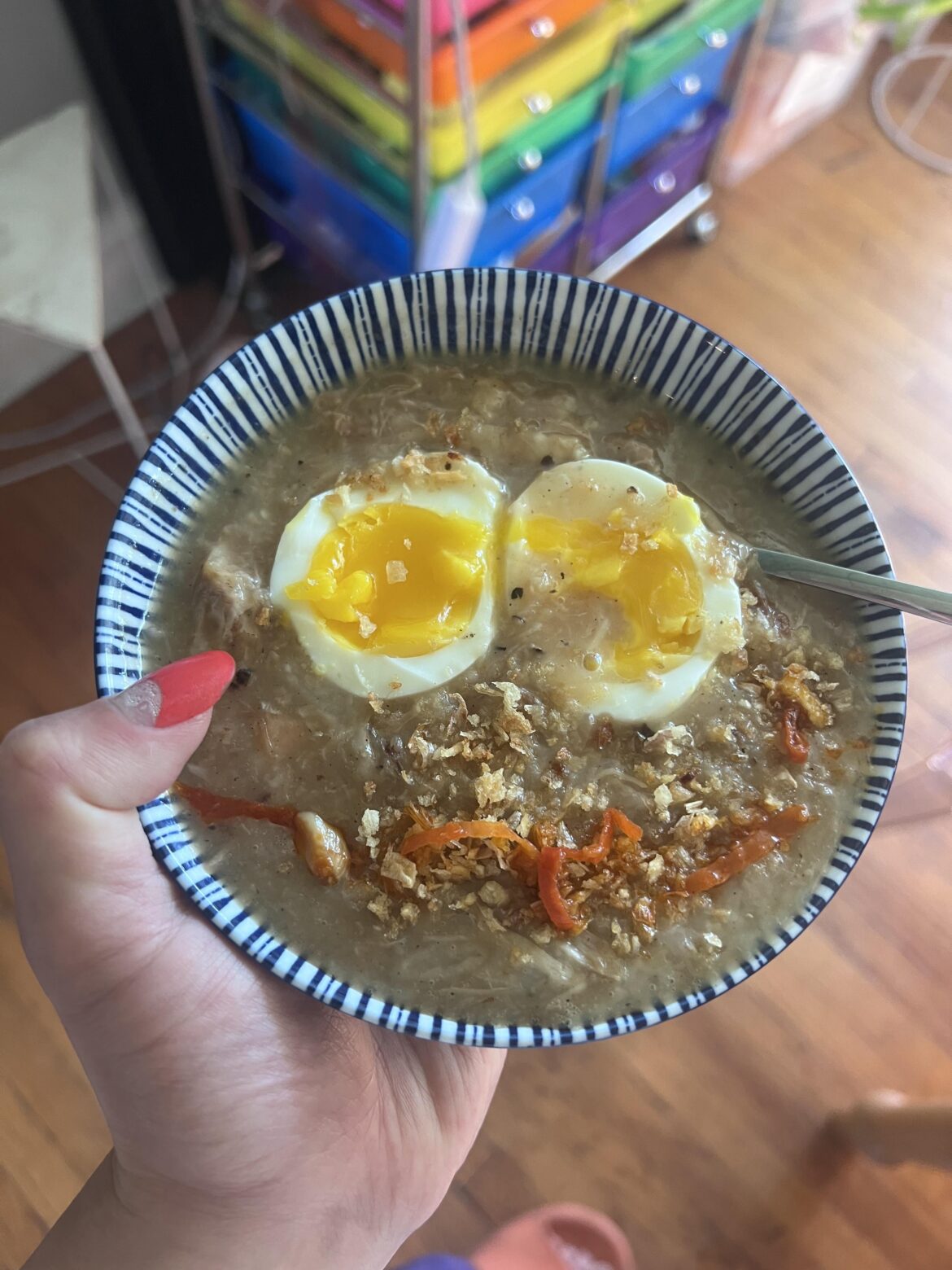 Arroz caldo with jammy egg, pickled chili, and fried garlic bits 🍳