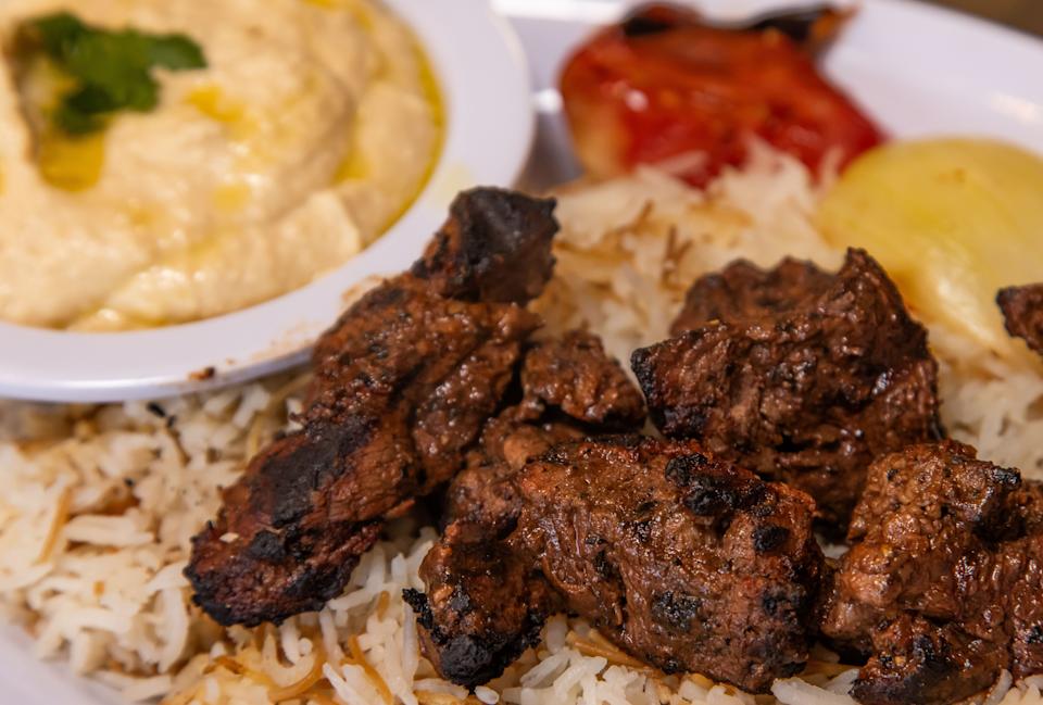 The Shish Kabob platter featuring filet mignon served on a bed of jasmine rice with a side of hummus, grilled onions and peppers, biwaz and a choice of salad or French fries at Cedar & Olive Mediterranean Grill in Jacksonville Beach.