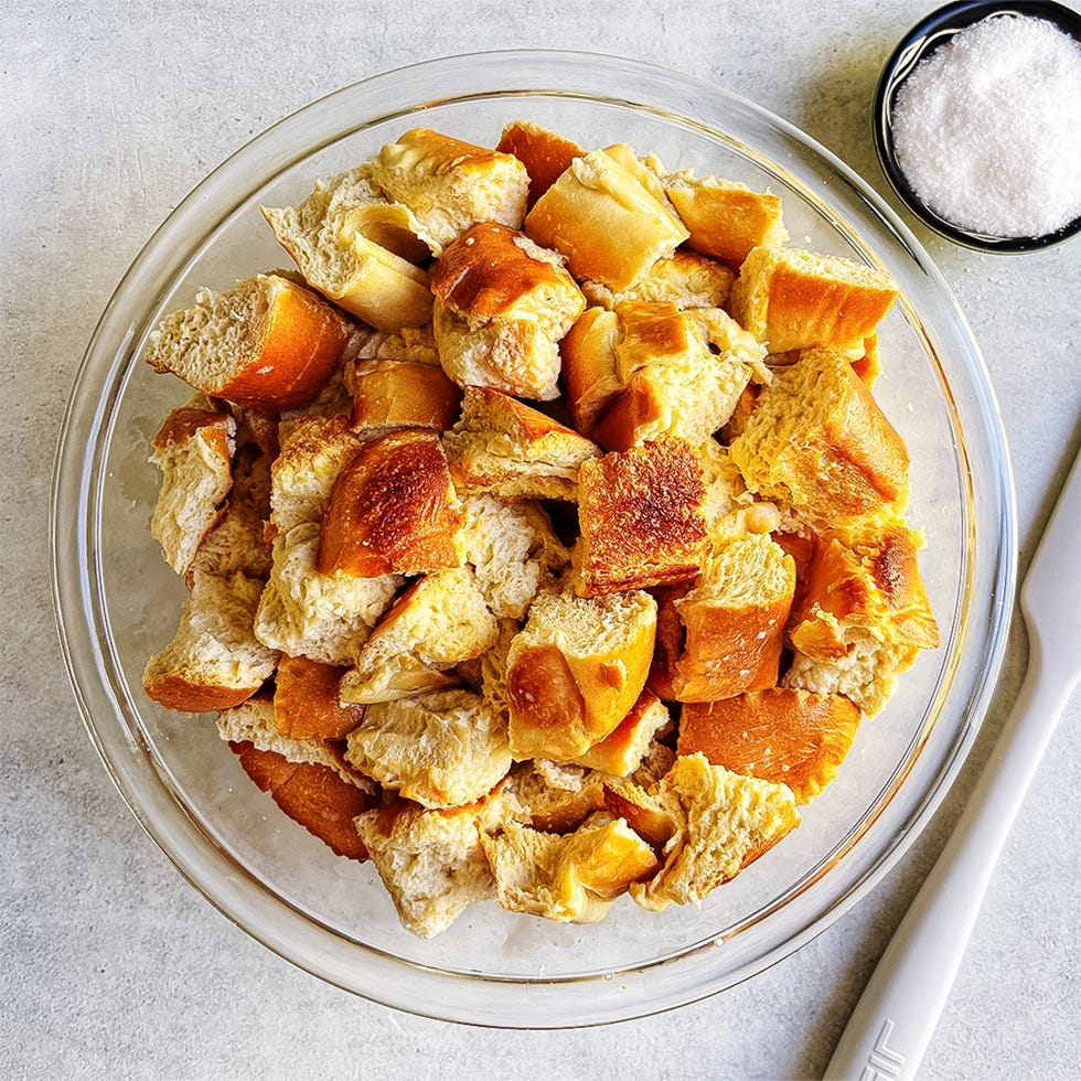 cubed bread in a bowl tossed with egg custard