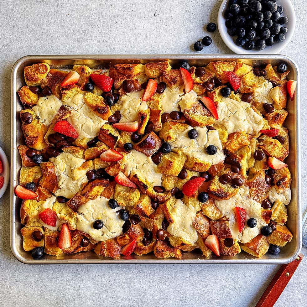 sheet pan french toast topped with ricotta, chocolate chips, and fresh berries