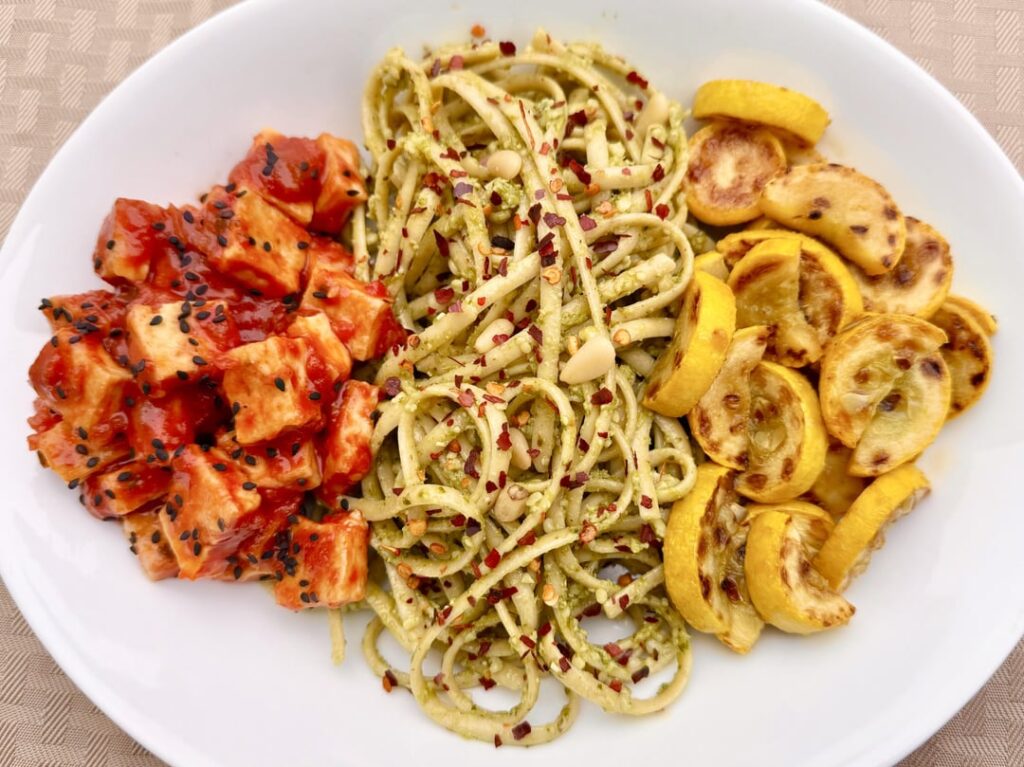 Linguini Pasta with Basil Pesto, Tofu with spicy Gochujang sauce, and Pan-roasted Yellow Squash with garlic.