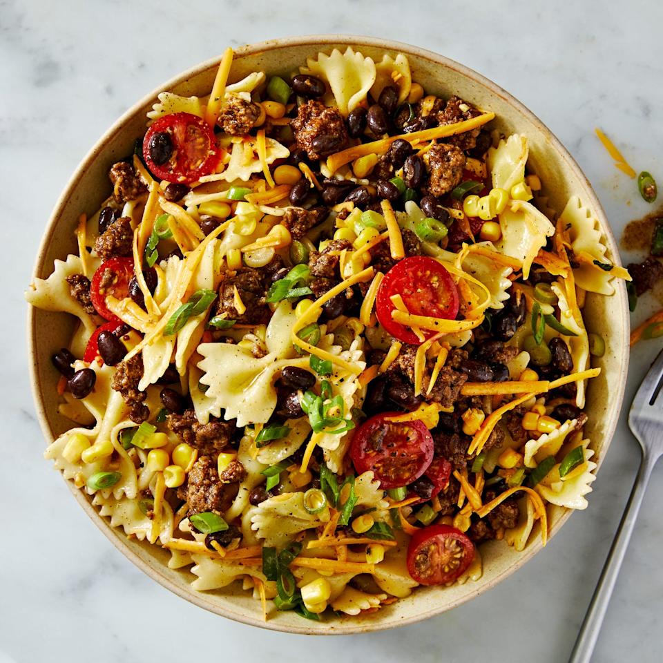 cowboy pasta salad with bowtie pasta, tomatoes, ground beef, cheese, corn, and black beans