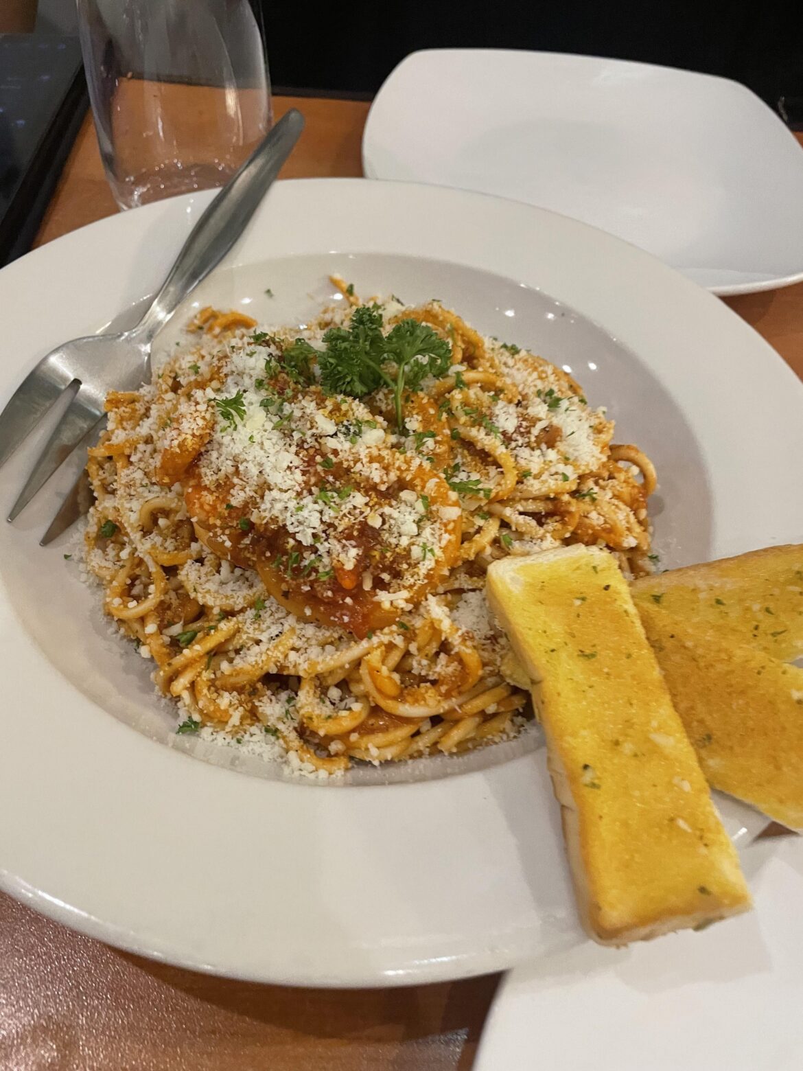 Bolognese cheesy pasta with a slice of garlic bread