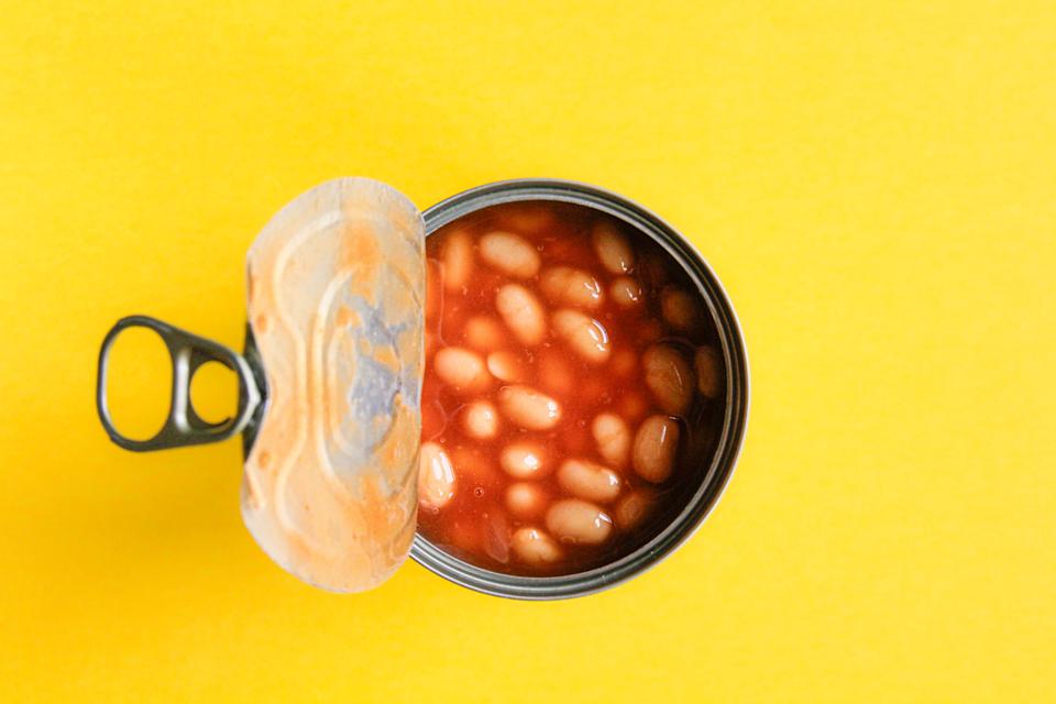 Canned baked beans on a yellow background