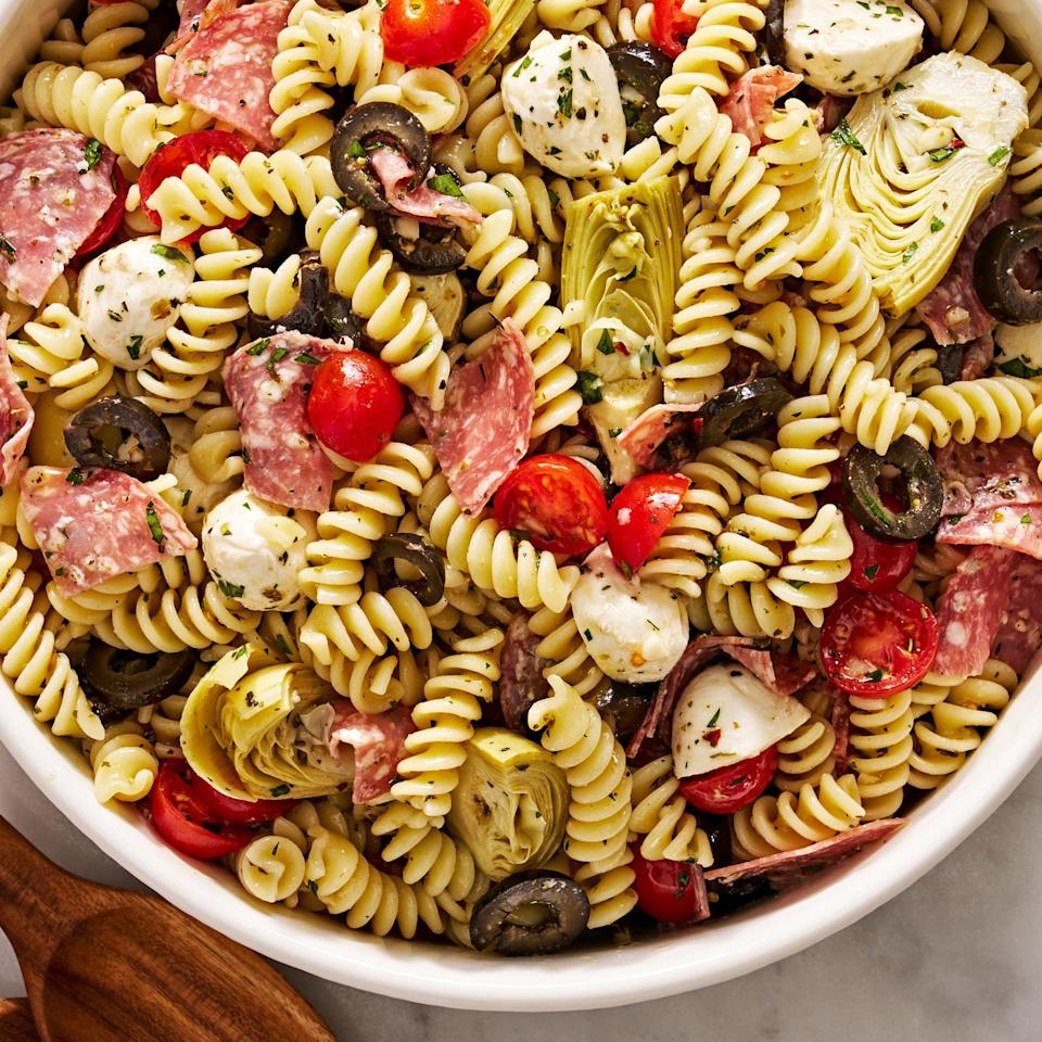 italian inspired pasta salad with cherry tomatoes, mozzarella, black olives, artichokes, and salami