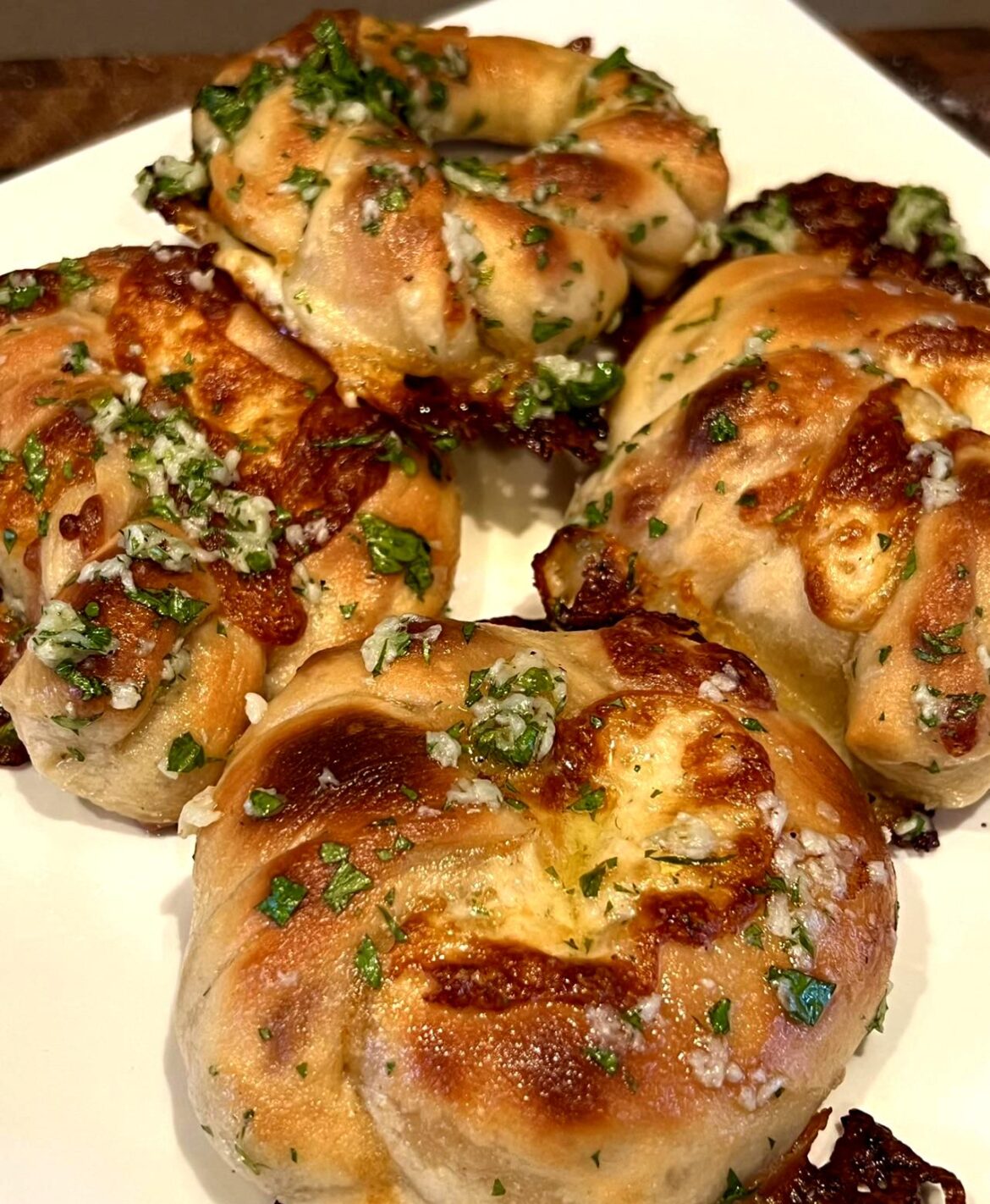 Garlic knots stuffed with mozzarella and bathed in butter garlic and Italian parsley.