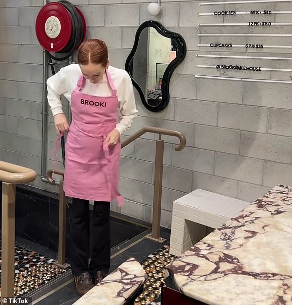 The baking influencer is pictured on Saturday dressing into her iconic 'Brooki' apron after briefly retreating from the limelight amid claims she had plagiarised recipes in her cookbook