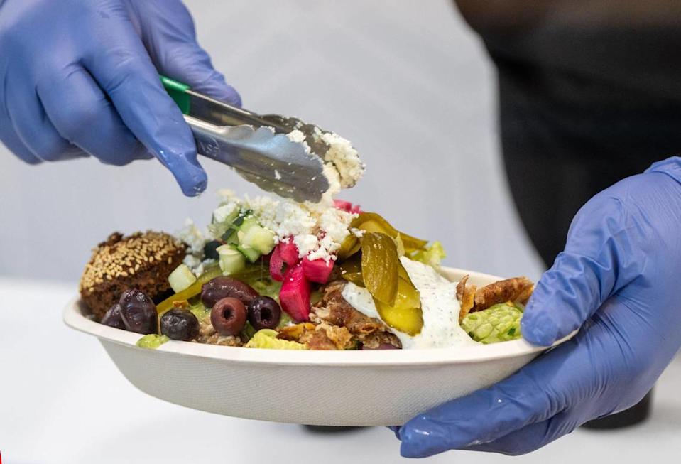 Jeremy Saunders creates a Chicken Shawarma bowl during a soft opening for Zhoug Mediterranean, 3904 Bell St., on Wednesday, May 14, in Kansas City.