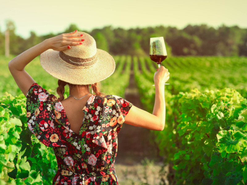 A woman drinking wine in a field