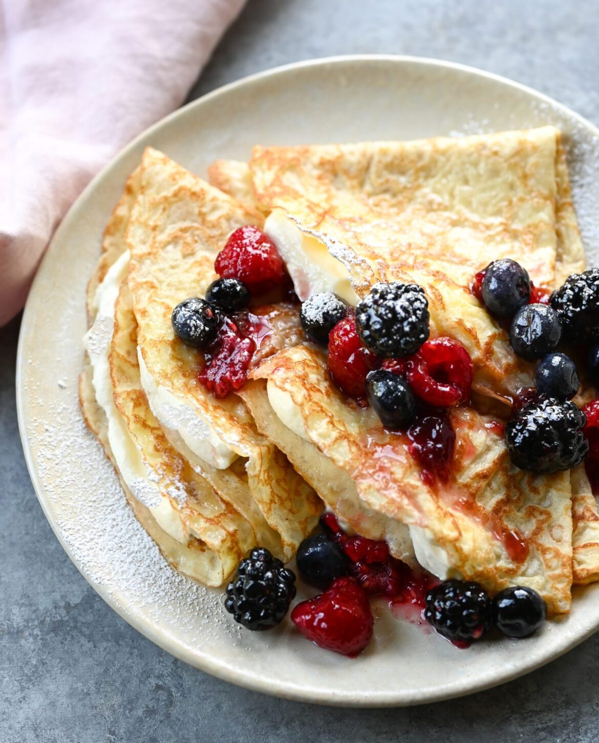 Classic French Crêpes Recipe – Sweet or Savory crepes on plate with cream and berries.