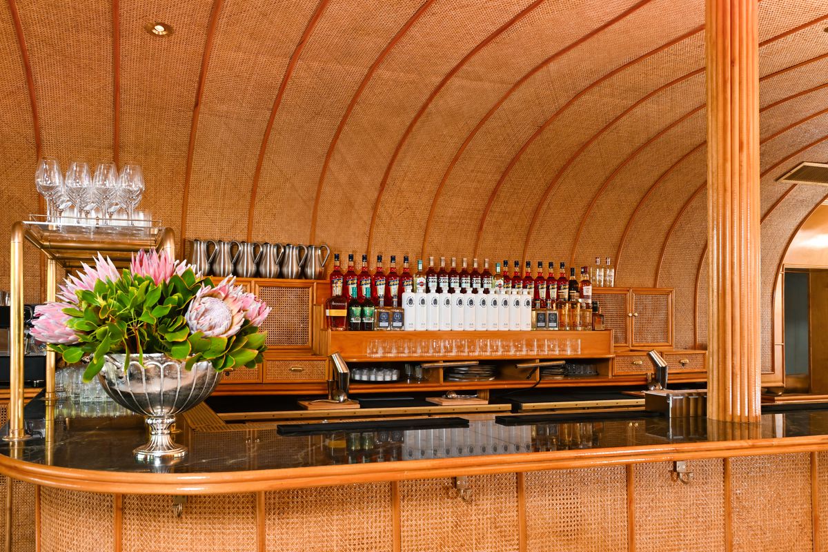 The bar at San Lorenzo with a vase of flowers to the left of it.