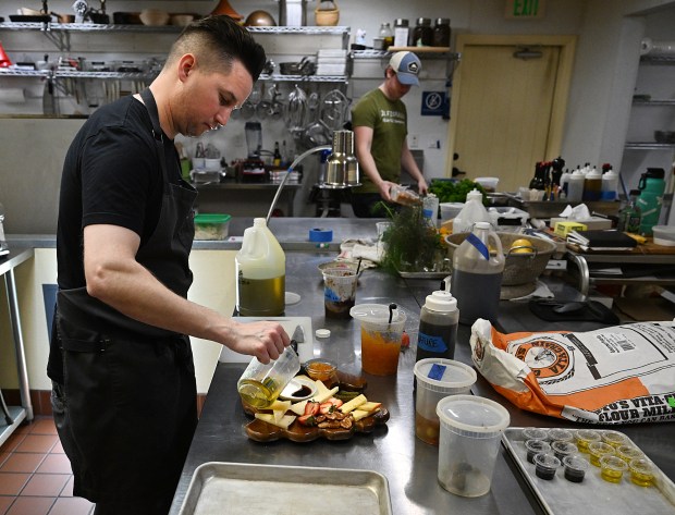 Chef Tim Saenz adds olive oil to a cheese board for the Il Fiorello Olive Oil Company bistro in the Suisun Valley. (Chris Riley/The Reporter)
