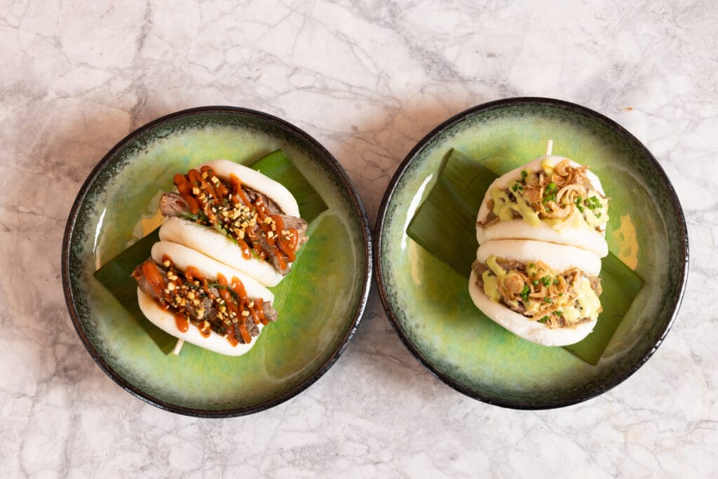 Bao buns on green plates at Kinjo in Newark