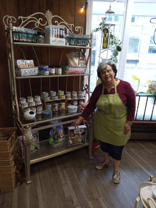 Tracy Lockhart, general manager of The Olive Scene in Vermilion, points to some of the olive oils and vinegars at the store. (Bob Stascak - For The Morning Journal)