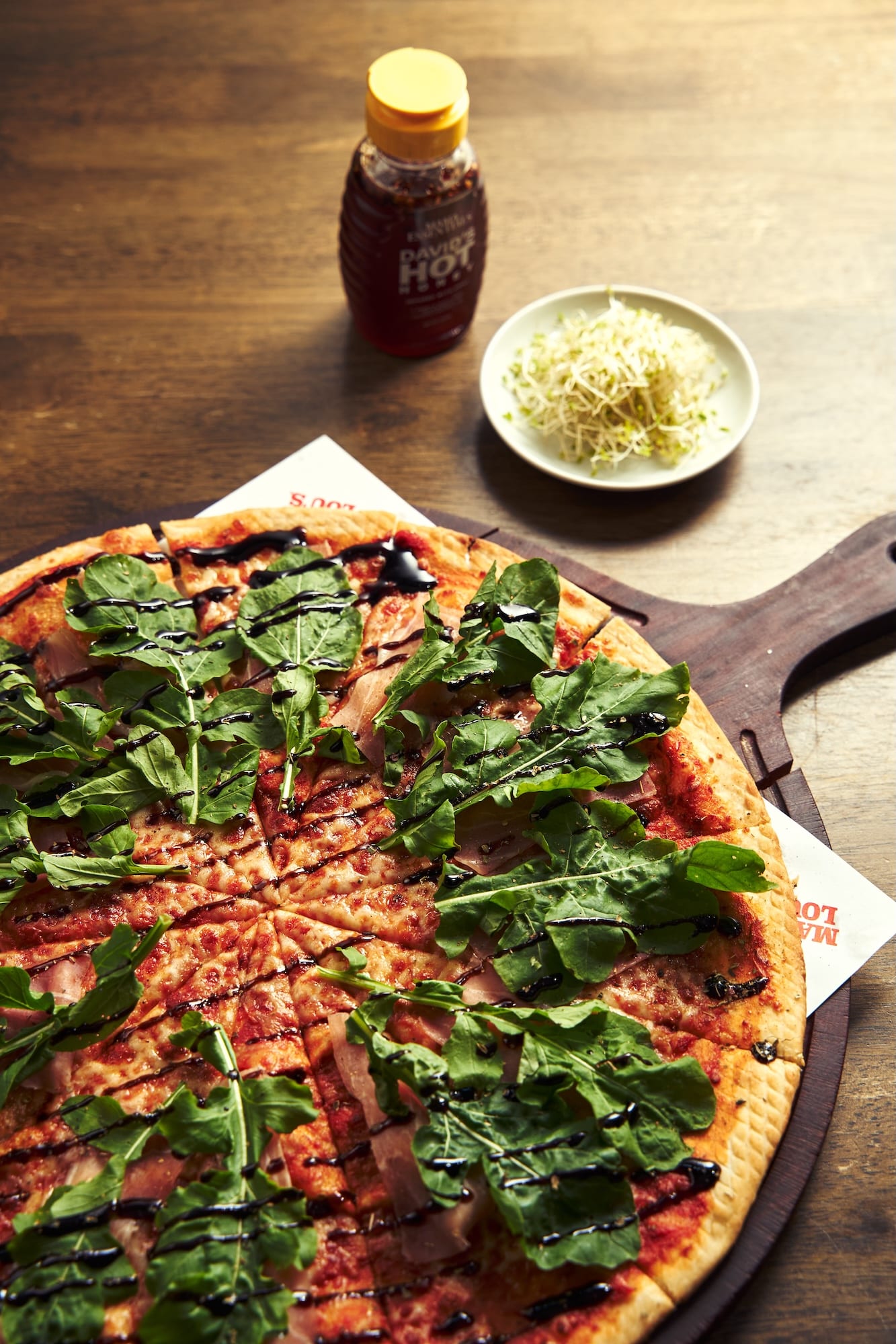 Mama Lou's Special (tomato sauce, mozzarella, prosciutto, ripe mangoes, arugula, balsamic glaze)