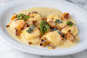 Pillowy ravioli with butternut squash sauce impresses at any course of a meal.