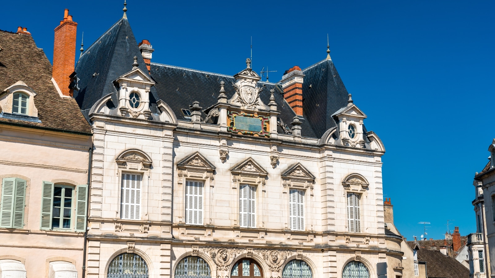 A photograph capturing Place de la Halle in Beaune, France. The architectural elements include traditional structures lining the square. 