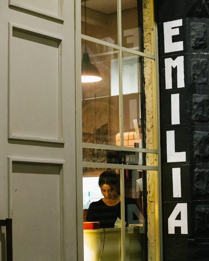 A shop front with a person in the window, a best Italian restaurant Melbourne CBD.