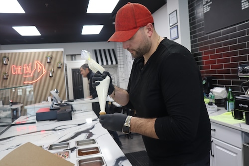 Nicholas D'Anna filling a cannoli at The Cannoli Shop in Fairfield, NJ