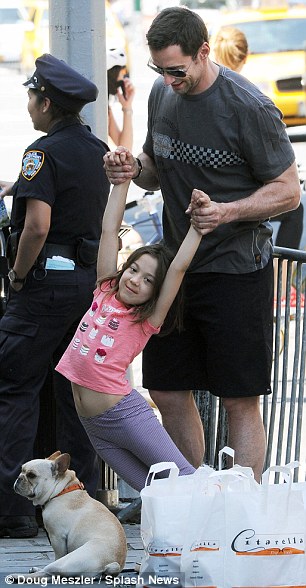 Dad, daughter, and a dog: Hugh Jackman gave his bulging biceps a workout this afternoon in New York as he held his beaming six-year-old daughter Eva up by her tiny arms