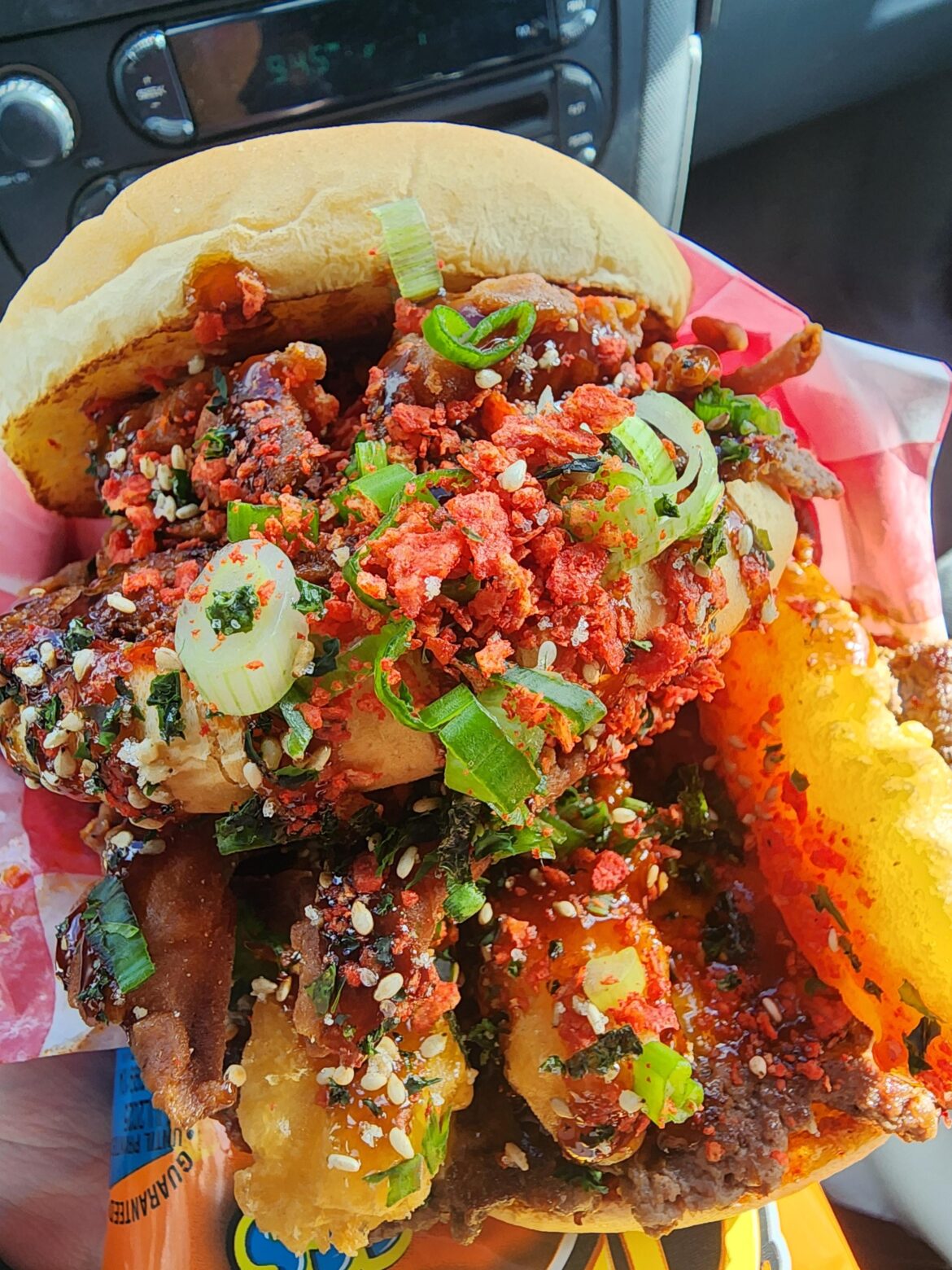 A food truck in my area makes these insane burgers. This is a Flaming Hot Smash burger unicorn style. It has a full deep fried soft shell crab, tempura shrimp, an extra bun like a big mac with 2 beef patties, cheese, BBQ sauce, chilli sauce and crushed up flaming hot doritos.