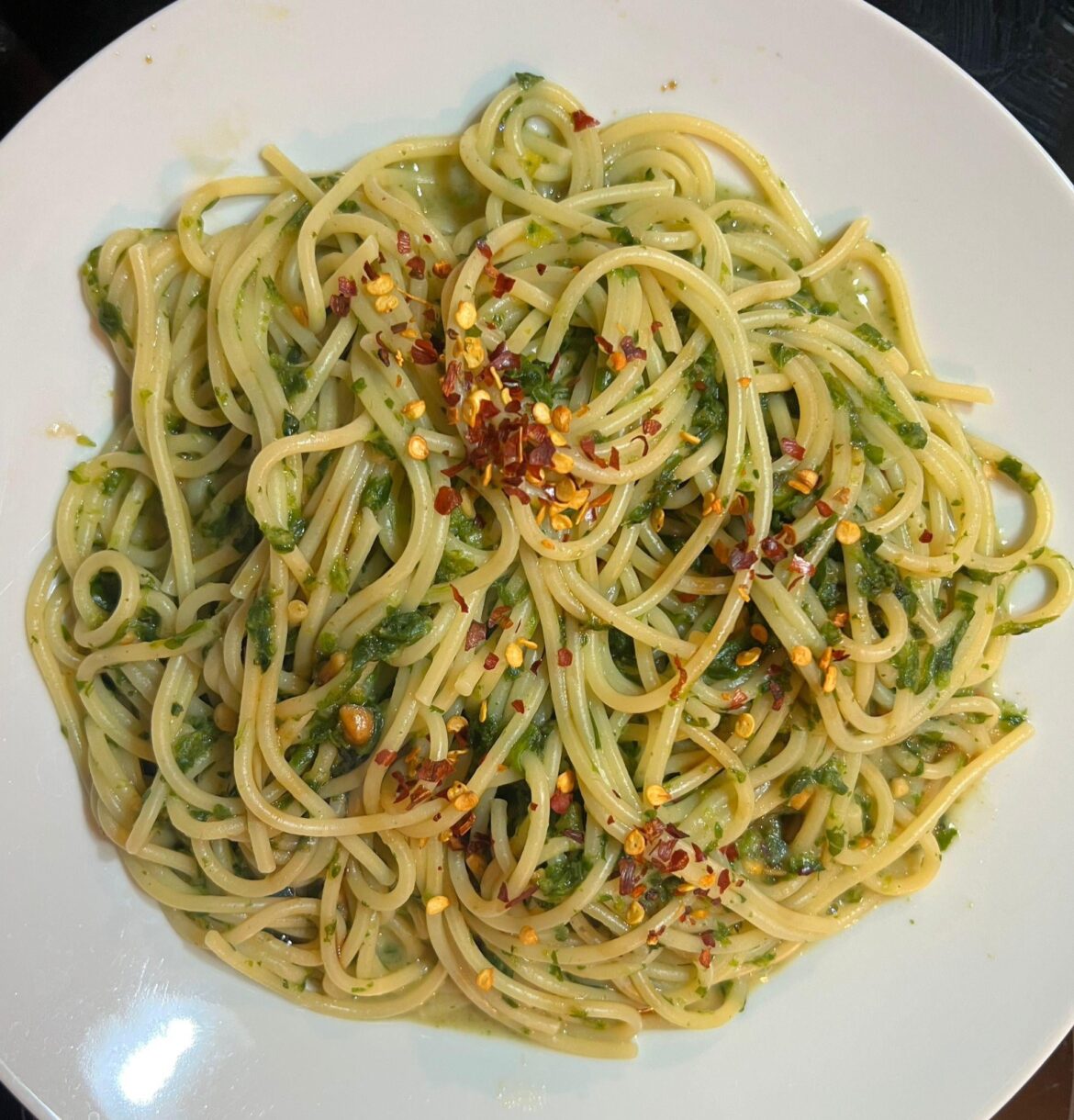 Spaghetti with spinach, peanut butter and crushed dry red chili