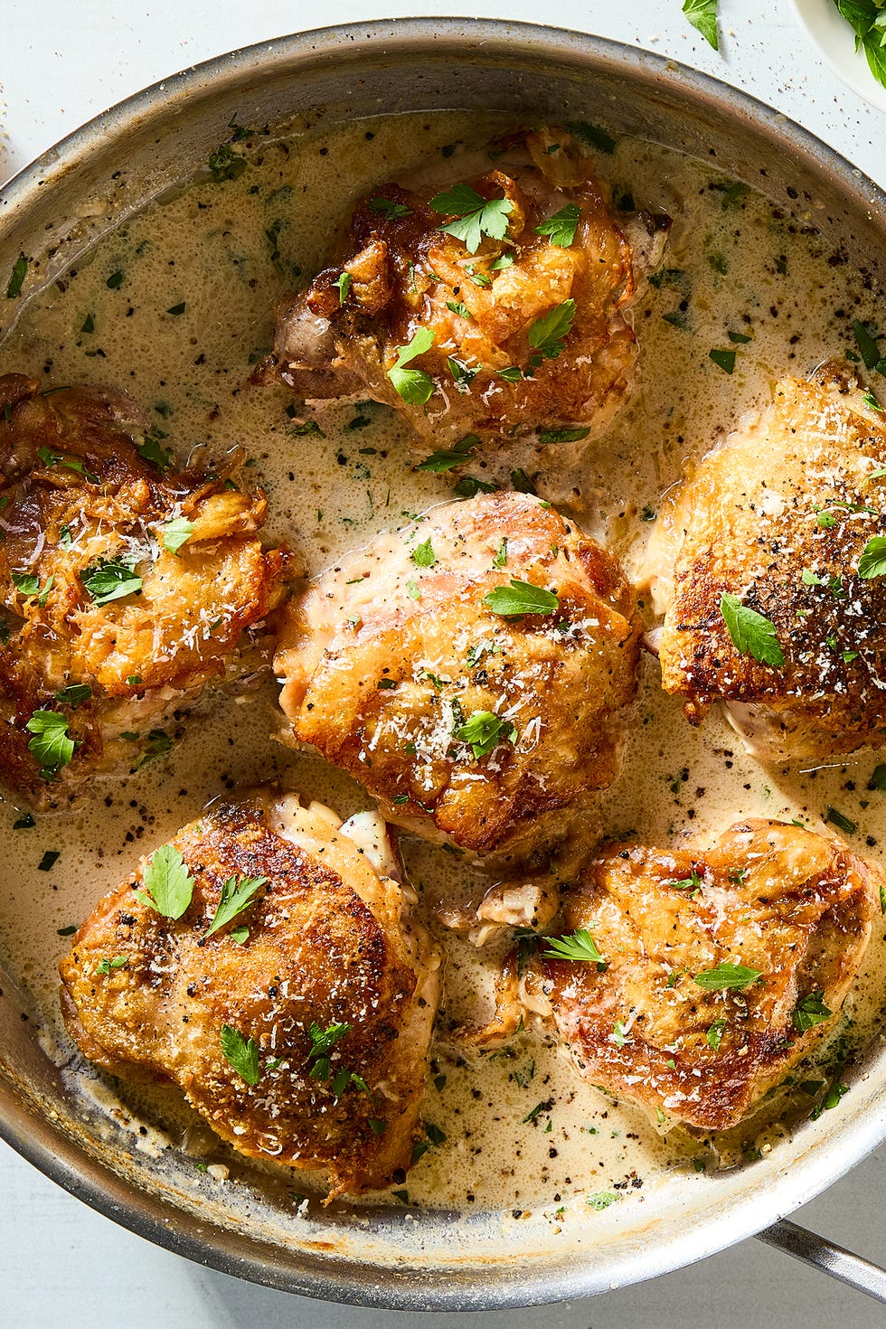 cacio e pepe chicken thighs with lemon wedges