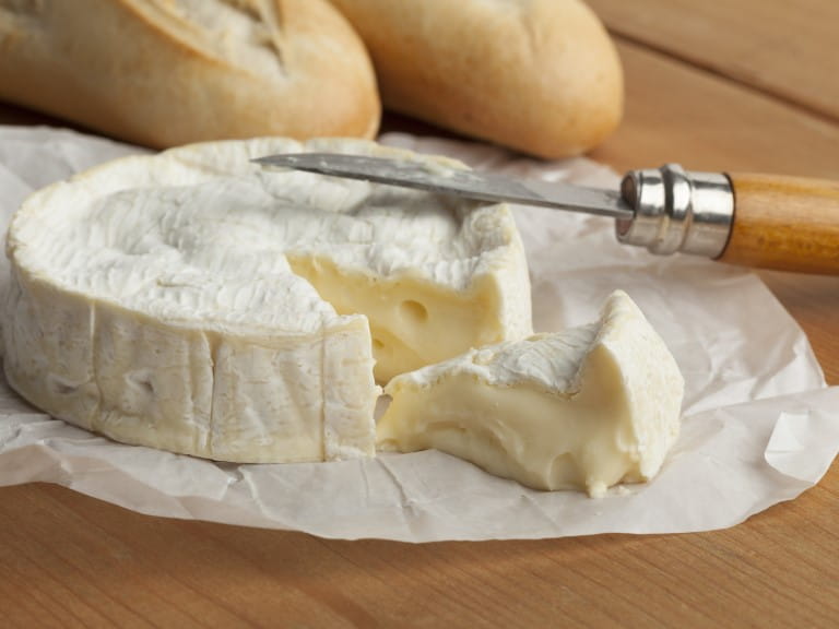 Camembert cheese with a slice cut out