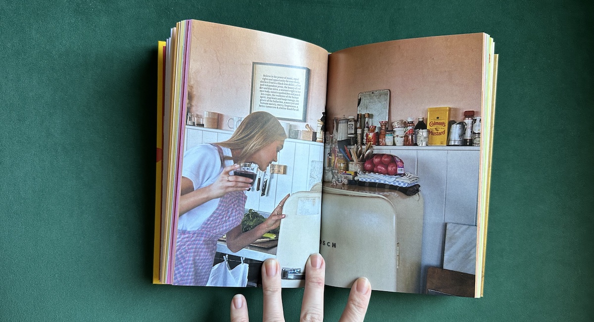 Open book showing picture of woman cooking in kitchen