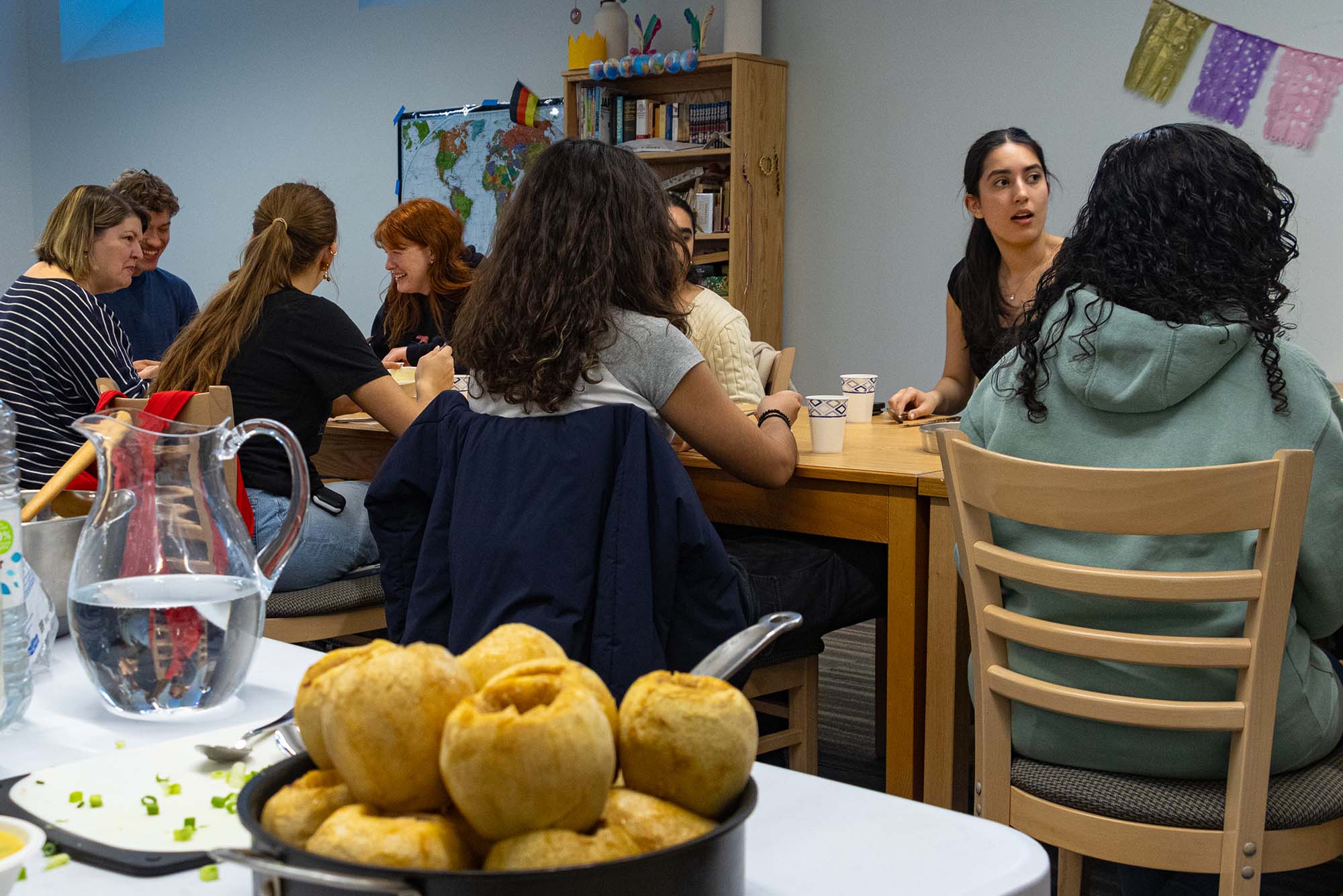 Students of LF307: French Arts and Society, as well as their professor, Senior Lecturer Maria Bobroff, enjoy a traditional French meal, prepared by Laura Dodd (CAS’25), Michael Sommese (COM’25), Mia Popovic (CAS’27) and Dorsa Hajmaghani (Pardee’27). The meal, prepared and served for the group’s final exam, consisted of baguettes and soup for starters, a salad, a tartiflette—a French dish containing bacon, potatoes and cheese, and a traditional French dessert consisting of sugar-filled baked apples. Photo by Ajani Hickling (CAS’27).