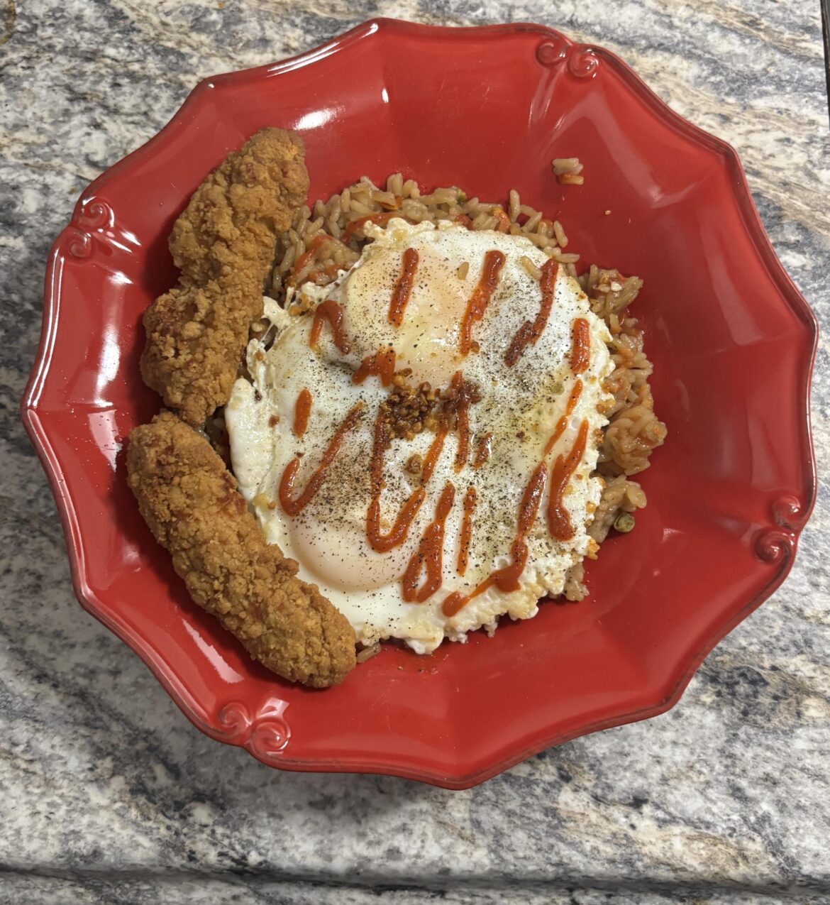 Garlic fried rice with chicken, two eggs over easy, and some fried garlic on top!