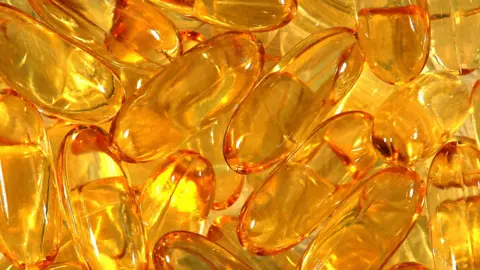 PA Media A generic view of dozens of cod liver oil capsules piled together