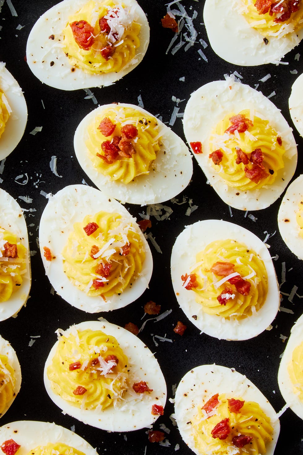 carbonara deviled eggs topped with pecorino romano and crispy pancetta