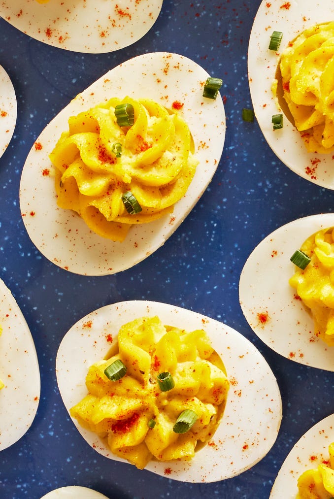 deviled eggs piped in a star shape with paprika and chives