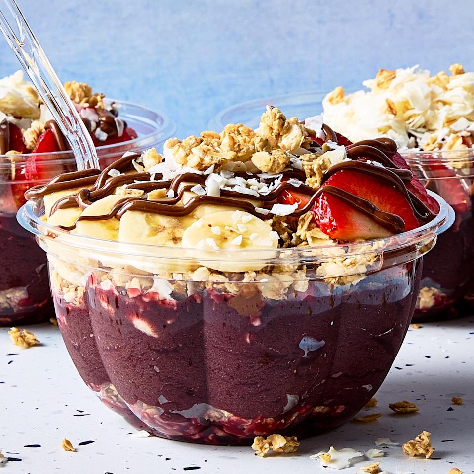 acai playa bowl topped with bananas, strawberries, coconut shreds, and granola